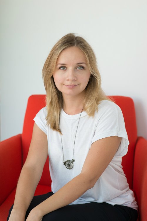 Yuliya sitting on an orange chair